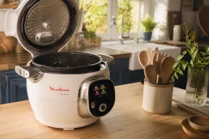Multicuiseur Cookeo ouvert sur un plan de travail en bois, cuve visible avec traces d'usure